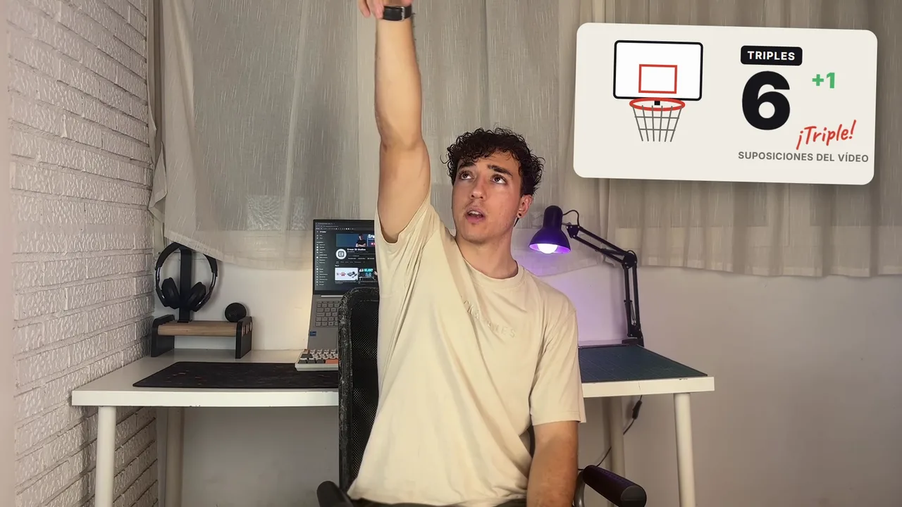 Erwan en su taller con el brazo levantado, como si tirara a canasta, al lado del contador de triples del vídeo marcando 6