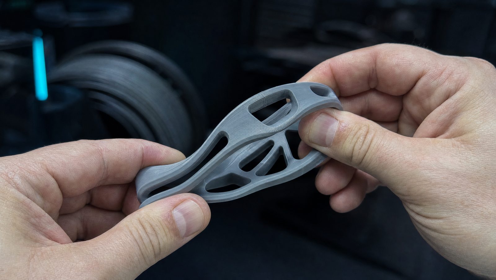 Pieza flexible impresa en TPU doblándose entre los dedos sin romperse