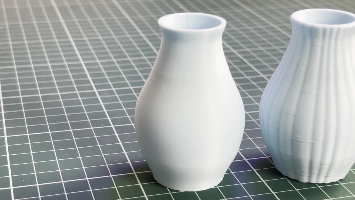 Dos jarrones azules impresos en 3D: uno liso y otro con estrías verticales