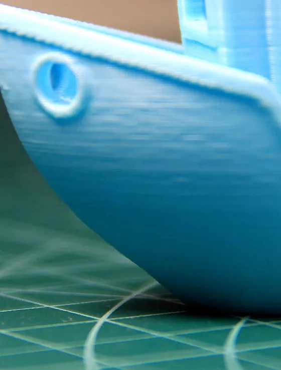 El costado de un Benchy azul desde el agujerito de la proa hacia atrás, con el casco liso