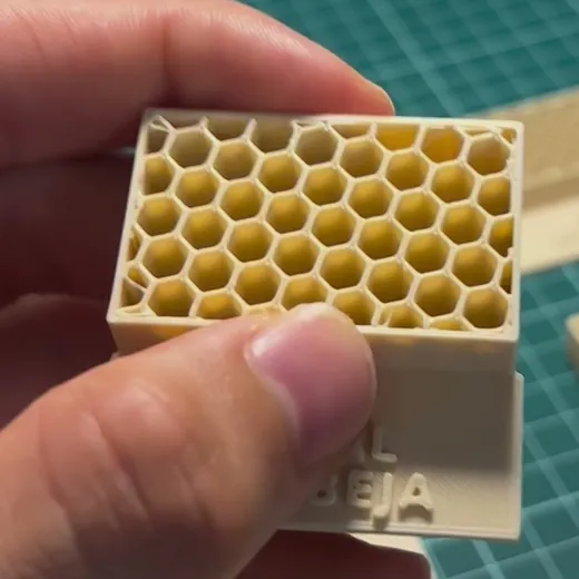 Bloque del muestrario con relleno de panal de abeja, sujeto con la mano: celdas hexagonales