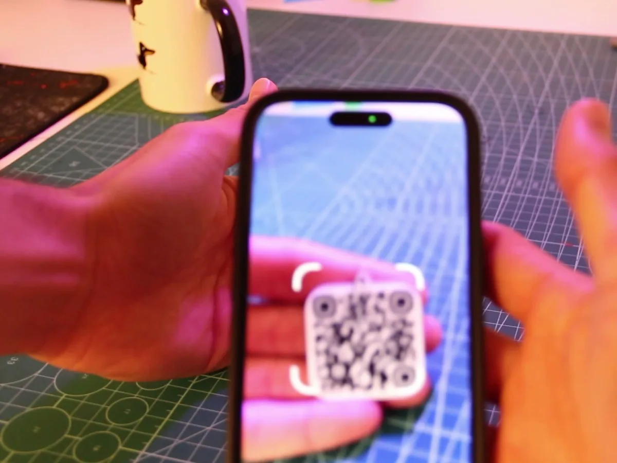 Un móvil escaneando un llavero con código QR impreso en 3D
