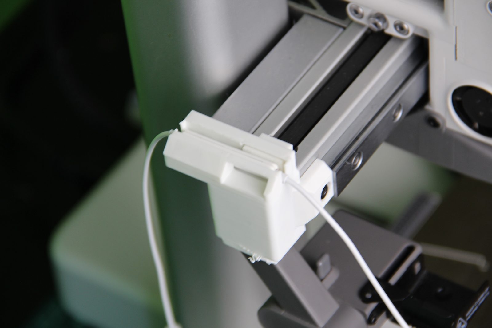 Detalle de la pieza del timelapse montada en la A1 con el cable de los auriculares saliendo de ella