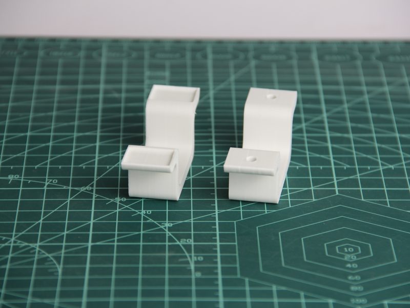 Dos clips organizadores de cables impresos en blanco